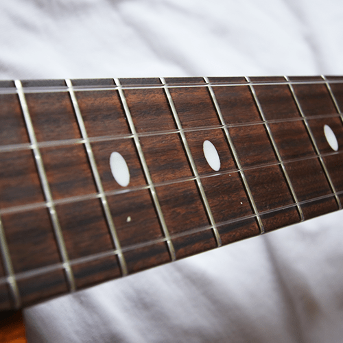 The frets on a ukulele fretboard